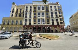 Personas transitan frente a un hotel de la cadena hotelera, en La Habana (Cuba).