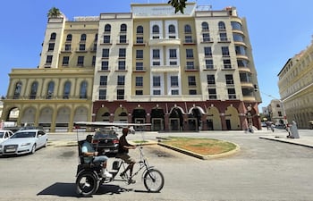 Personas transitan frente a un hotel de la cadena hotelera, en La Habana (Cuba).