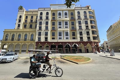 Personas transitan frente a un hotel de la cadena hotelera, en La Habana (Cuba).