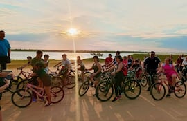 El turismo generó un importante ingreso económico en Ñeembucú. En la foto se observa un paseo en bicicleta a orillas del río Paraguay al atardecer.