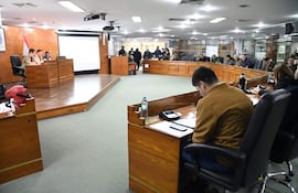 Miguel Sosa y Arturo Almirón Tuki en la mesa, vestidos formalmente, mientras un grupo los observa en un recinto legislativo.