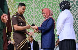 Agentes del orden revisan palos de ratán durante una flagelación pública en Banda Aceh el 4 de junio de 2025. Un hombre y una mujer fueron azotados públicamente 100 veces cada uno en la conservadora provincia indonesia de Aceh el 4 de junio, tras ser declarados culpables de relaciones sexuales fuera del matrimonio por un tribunal que opera bajo la estricta ley islámica.
