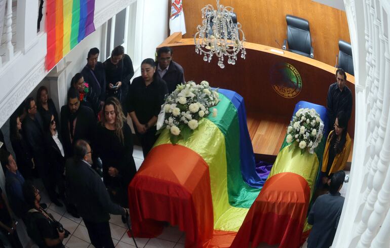 Los ataúdes de "le magistrade" Jesús Ociel Baena y su pareja, cubiertos con la bandera del arcoiris.