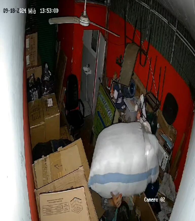 Uno de los maleantes forzó las cerraduras de una empresa transportadora, que está instalada en la misma zona y se dispone a escapar del lugar con una bolsa cargada de mercaderías al hombro.