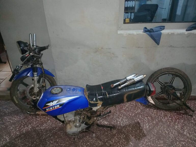 Motos Kenton despojadas de asientos, una con motor expuesto, en un taller con piso de granito.
