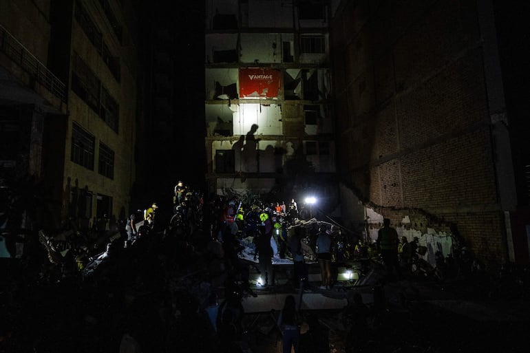 Una multitud de personas busca sobrevivientes en un edificio parcialmente colapsado en Pereira.