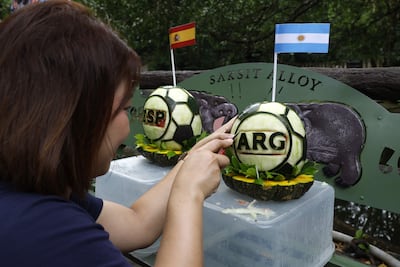 Chonburi (Tailandia), 18/07/2026.- Un cuidador de zoológico talla sandías con forma de balón de fútbol decoradas con las banderas nacionales de España (izquierda) y Argentina (derecha) para que el hipopótamo pigmeo Moo Deng prediga el ganador de la final de la Copa Mundial de la FIFA 2026 entre España y Argentina, en el zoológico abierto de Khao Kheow, en la provincia de Chonburi, Tailandia, el 18 de julio de 2026.