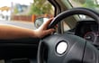 Una persona con las manos al volante.