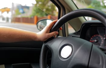 Una persona con las manos al volante.