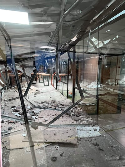 Interior del quincho del Congreso Nacional, con escombros y daños visibles en el techo y el suelo, sin personas presentes.