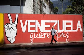 Una persona camina frente a un mural este jueves, en Caracas (Venezuela).