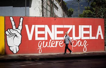 Una persona camina frente a un mural este jueves, en Caracas (Venezuela).