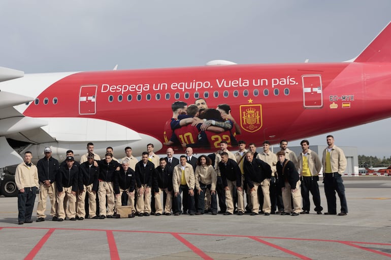 Los jugadores y el cuerpo técnico de la selección española posan ante el avión que llevó al equipo a EEUU antes de que embarquen en el aeropuerto de Santiago de Compostela.