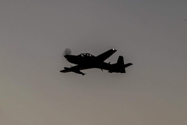Aeronave militar en vuelo, capturada durante el atardecer, sin personas visibles en la imagen.