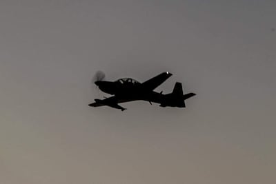 Aeronave militar en vuelo, capturada durante el atardecer, sin personas visibles en la imagen.