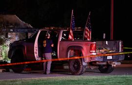 Un agente del Equipo de Respuesta a Evidencias del FBI inspecciona la camioneta del sospechoso frente a la Iglesia de Jesucristo de los Santos de los Últimos Días en Grand Blanc, Michigan.