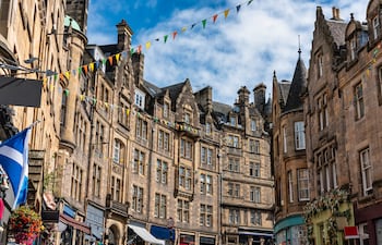 Calle comercial Cockburn con coloridas tiendas y viejos edificios de piedra en Edimburgo, Escocia.