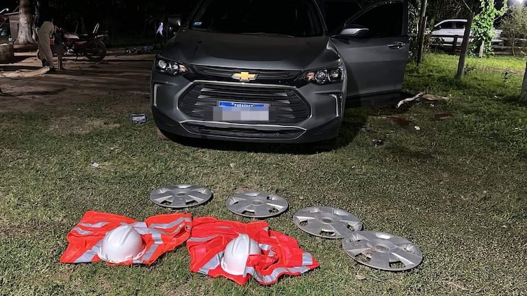 Vehículo utilitario Chevrolet con puerta abierta, cubrerruedas y cascos de seguridad en un entorno rural nocturno.
