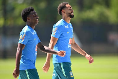 Vinícius Júnior (izquierda) camina sonriente con Matheus Cunha en el entrenamiento de Brasil.