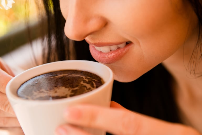 Mujer toma café.