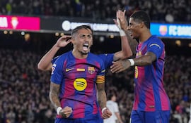 El delantero brasileño del FC Barcelona Raphinha (i) celebra con sus compañeros el gol marcado ante el Osasuna durante el partido de la jornada 16 de LaLiga que FC Barcelona y Atlético Osasuna disputan este sábado en el Camp Nou.