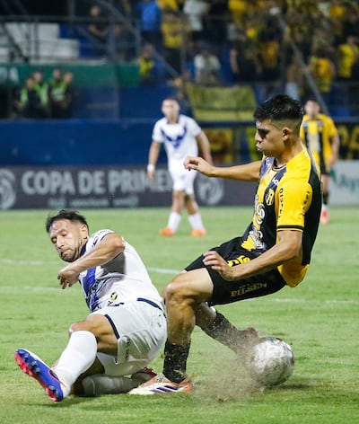 El mediocampista argentino Patricio Tanda intenta meter el pase ante el oportuno cruce del zaguero local Julio González Trinidad.
