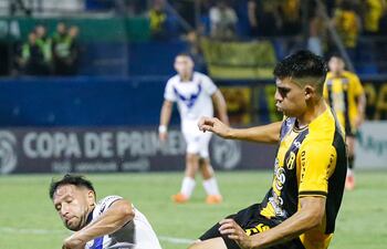 El mediocampista argentino Patricio Tanda intenta meter el pase ante el oportuno cruce del zaguero local Julio González Trinidad.