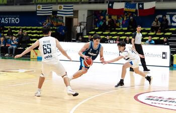 El oriental Felipe Linares elude la marca de Iván Nuevo y Benjamín Sánchez de la selección paraguaya, que cayó 83-58 contra Uruguay.