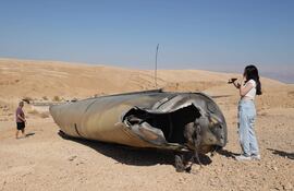 Imagen ilustrativa: gente revisa los restos de un misil balístico iraní en las afueras de la ciudad de Arad, en el sur de Israel.