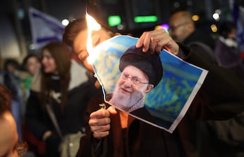 Un miembro de la comunidad iraní israelí quema una imagen del Líder Supremo de Irán, Alí Jamenei, durante una protesta en apoyo al pueblo iraní, en la ciudad de Holón, Israel.