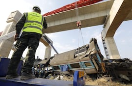 Rescatistas trabajan en los restos de un tren de pasajeros tras el desplome de una grúa de construcción sobre él en el distrito de Sikhio, Nakhon Ratchasima, Tailandia.
