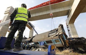 Rescatistas trabajan en los restos de un tren de pasajeros tras el desplome de una grúa de construcción sobre él en el distrito de Sikhio, Nakhon Ratchasima, Tailandia.