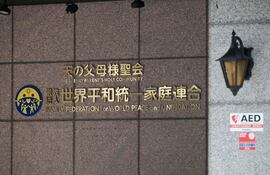 El logotipo de la Federación de Familias para la Paz y la Unificación Mundial (FFWPU), conocida como la Iglesia de la Unificación, se ve en la entrada de la sede de la sucursal japonesa en Tokio. Se espera que el Tribunal de Distrito de Tokio anuncie el 25 de marzo su decisión sobre la disolución de la influyente secta, que había sido objeto de un intenso escrutinio tras el asesinato del ex primer ministro japonés Shinzo Abe durante la campaña electoral de 2022, presuntamente a manos de un hombre resentido con la Iglesia de la Unificación.