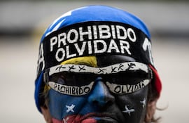 Una persona se manifiesta para reclamar que se convoque a unas elecciones libres en el país, este jueves, en Caracas (Venezuela).