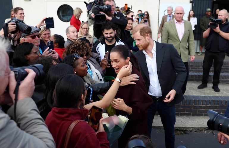El príncipe Harry y su esposa Meghan saludan a los simpatizantes al marcharse tras su visita al Community Recording Studio (CRS) en Nottingham. (Darren Staples / AFP)