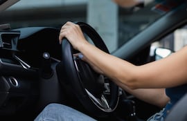 Una persona con las manos al volante.