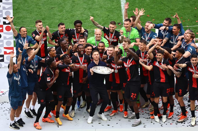 Xavi Alonso (c) y los jugadores del Bayer Leverkusen celebran con el trofeo de la Bundesliga en el Bay Arena, en Leverkusen.