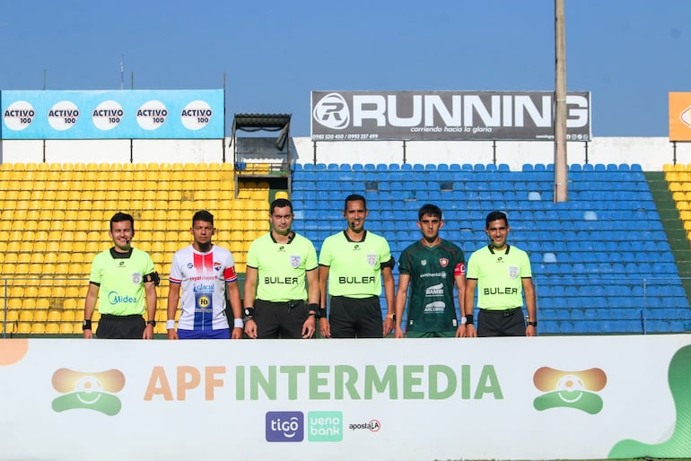 De frente al intenso astro rey, los capitanes de ambos equipos posaron junto a la terna arbitral en Capiatá.