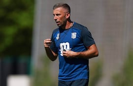 Gary O'Neil vestido con camiseta azul y pantalones cortos, gesticulando en un campo de entrenamiento con césped.