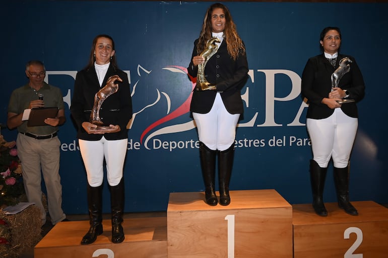 Leticia León (c) campeona en Adiestramiento Novicios Mayor, 2ª Aracelli Páez (d) y 3ª María Babuglia, con sus trofeos.