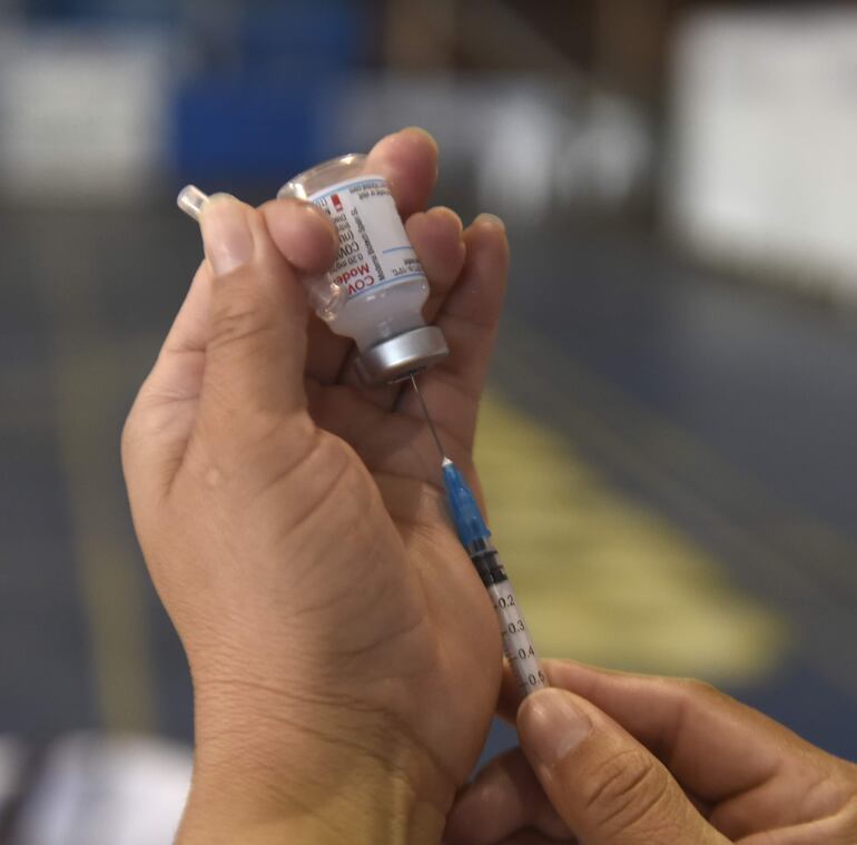 Una persona prepara una dosis de la vacuna antiCOVID de Moderna.