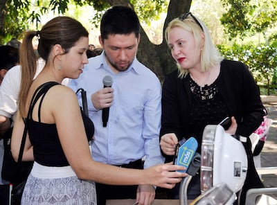 Técnicos del billetaje electrónico explican a una joven con discapacidad visual cómo funciona el validador. Dos máquinas quedan en el Senadis para que los interesados se familiaricen con el uso.