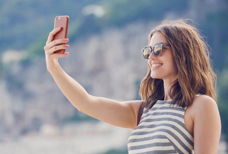 Mujer toma una foto para redes sociales con el smartphone.