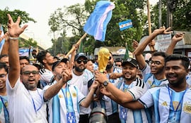 Aficionados cargan banderas de Argentina y una réplica del trofeo en apoyo a Argentina durante el actual torneo de fútbol de la Copa Mundial 2026.