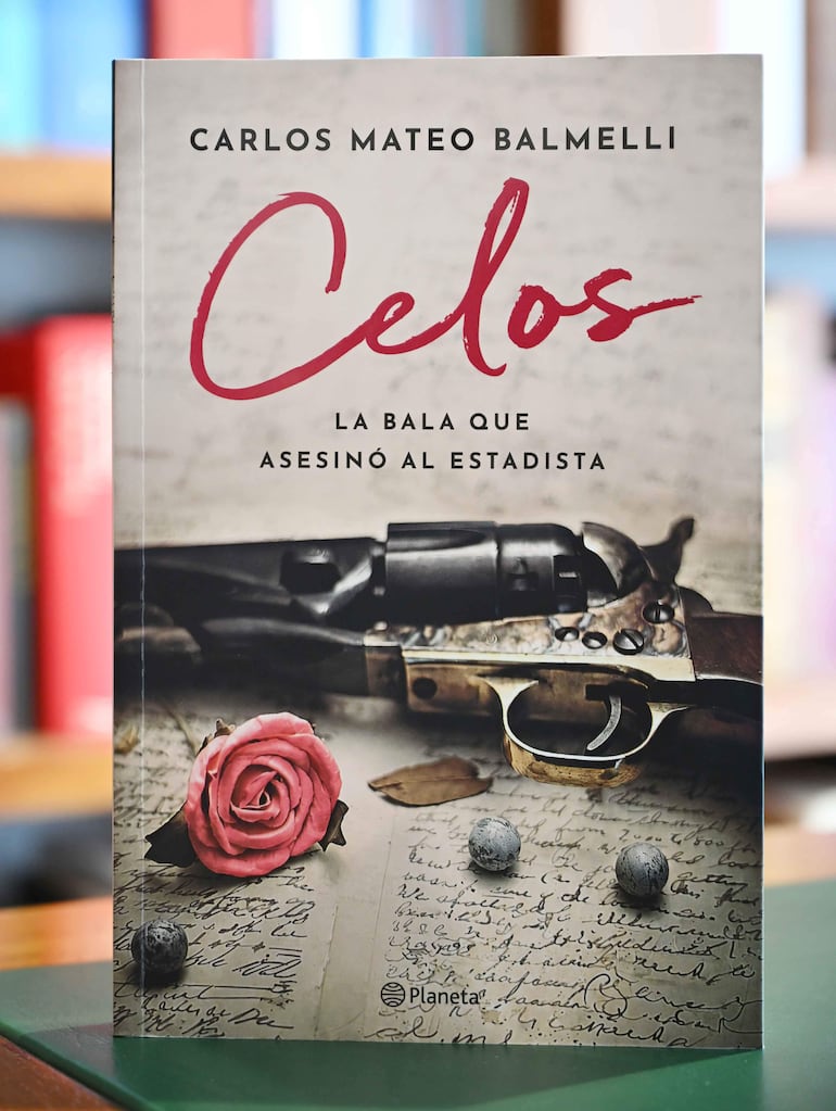 Portada del libro 'Celos' con una pistola antigua, rosa y objetos esféricos sobre papel manuscrito.