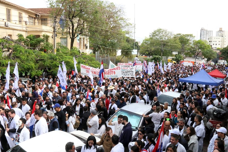 Un grupo de médicos participa en una protesta este lunes, en Asunción (Paraguay). Médicos del sector público marcharon y protagonizaron concentraciones en Paraguay, en el primer día de una huelga general que han convocado hasta el viernes para exigir un reajuste salarial, mejores condiciones laborales y la dotación de insumos y medicamentos en los hospitales. EFE/ Nina Osorio