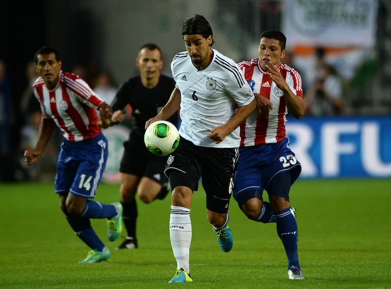 El mediocampista de Alemania, Sami Khedira domina el balón ante la marca del volante Richard Ortiz y la presencia cercana de Paulo Da Silva.