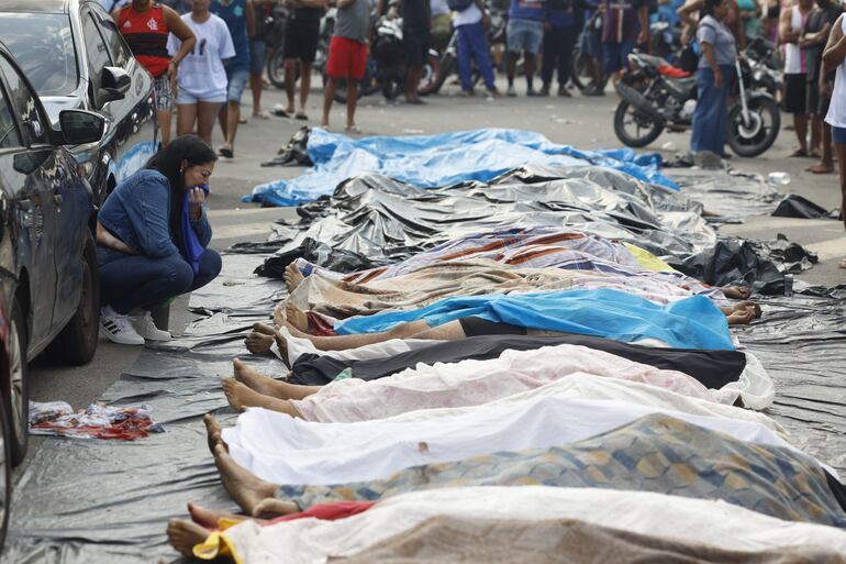 Una mujer llora frente a cuerpos sin vida en una calle este miércoles, en Río de Janeiro (Brasil). 