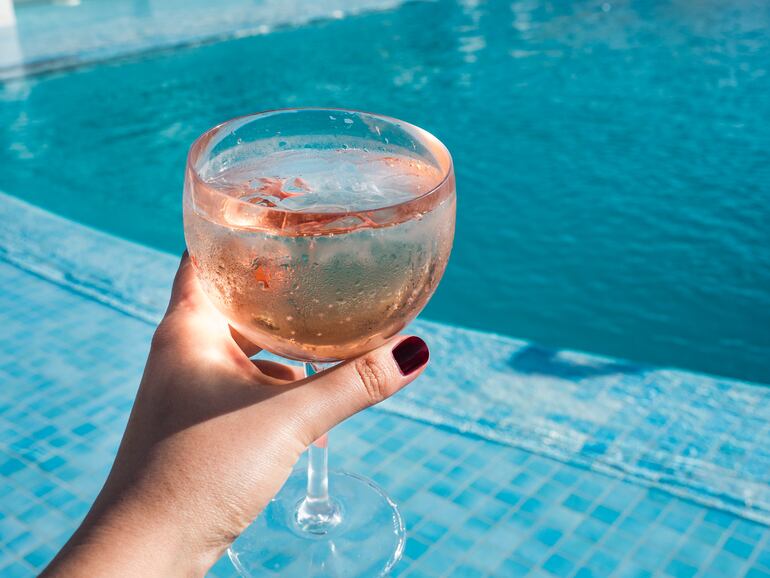 Un clásico de los días calurosos: una copa de vino rosado junto a la piscina.