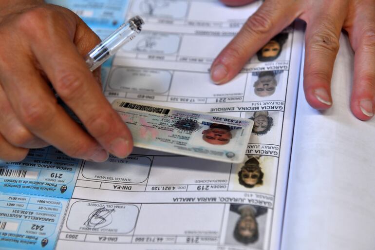 Un jurado de mesa confirma la identidad de un votante para las elecciones presidenciales, en Buenos Aires (Argentina).  (EFE)